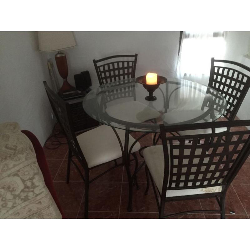 Round wrought iron table with glass top and 4 chairs. Delivery available