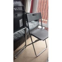 2 x black Ikea folding chairs with cushions