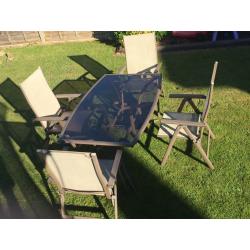 Glass top garden table and 4 reclining chairs.