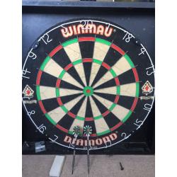 Winmau Dartboard in wooden cabinet.