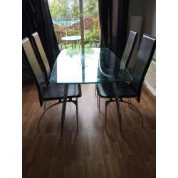 Glass table with 4 black chairs