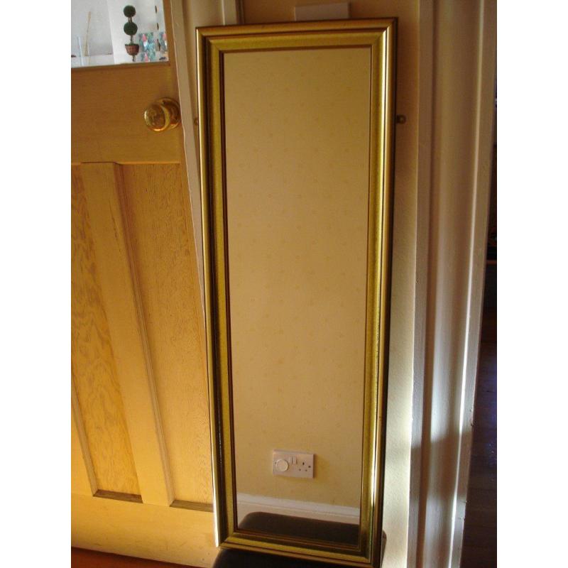 Gilt edged full length mirror, 32 cm by 93 cm, with brackets for hanging.